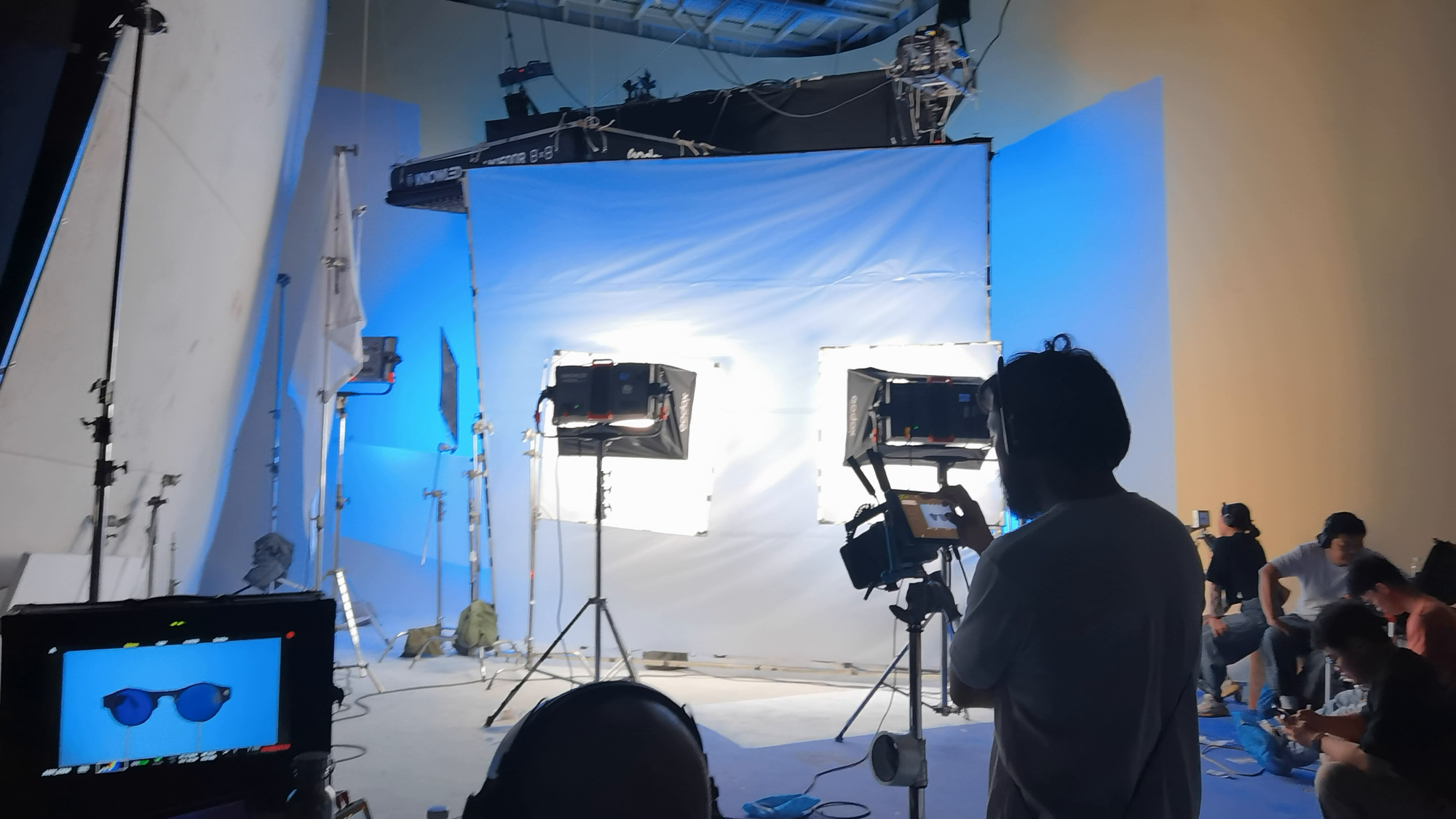 Crew filming a close camera-glasses product shot on a white studio set