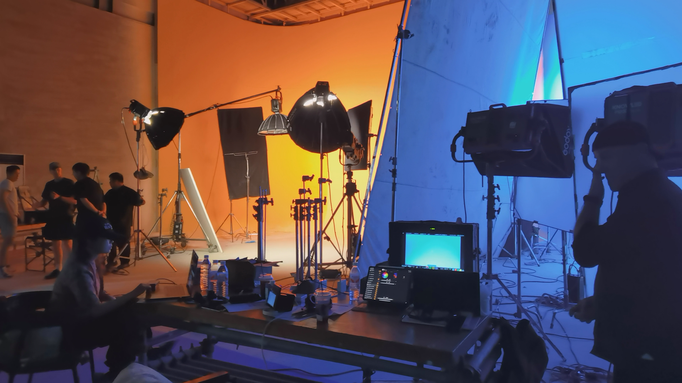 Studio team working across the orange-and-blue lighting setup