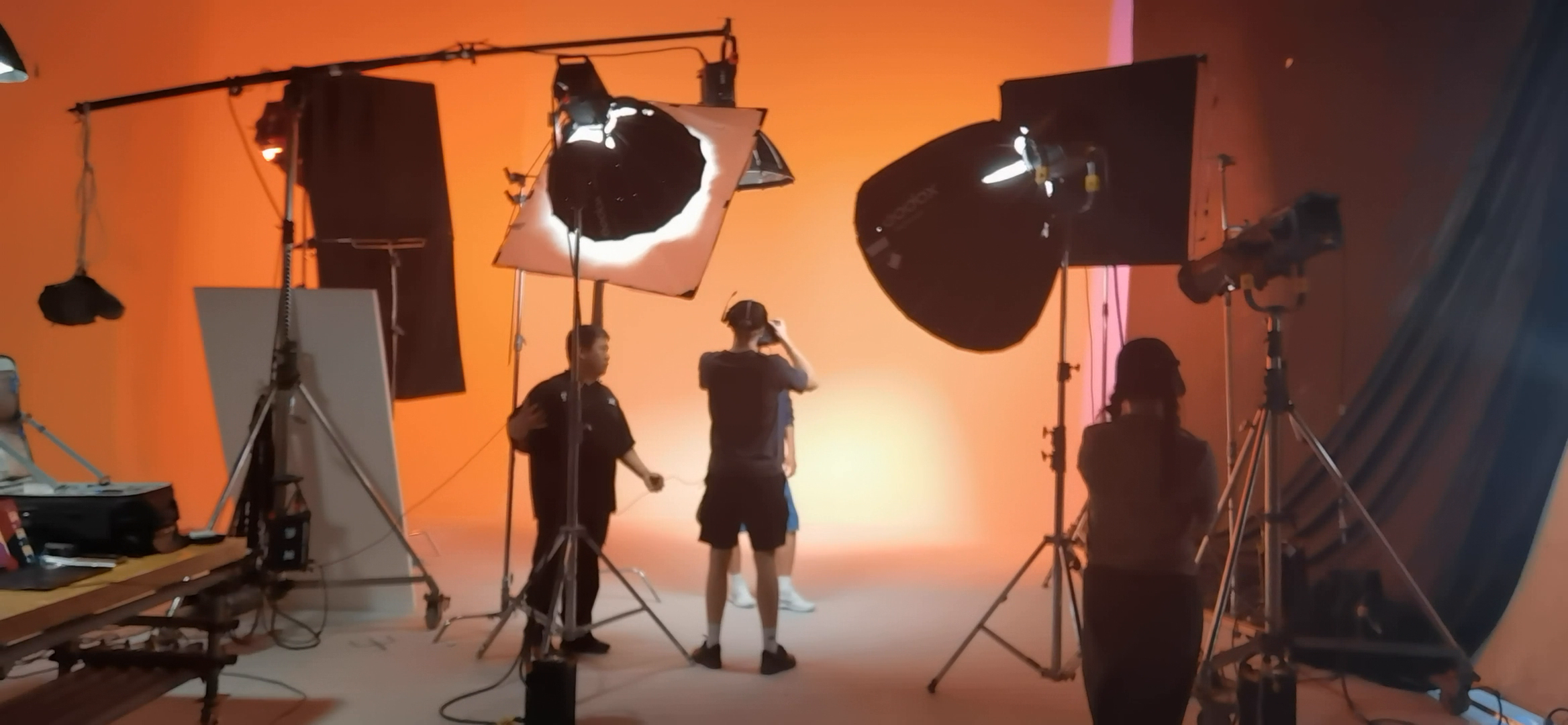Camera crew working under warm orange studio lighting during an 8ight production