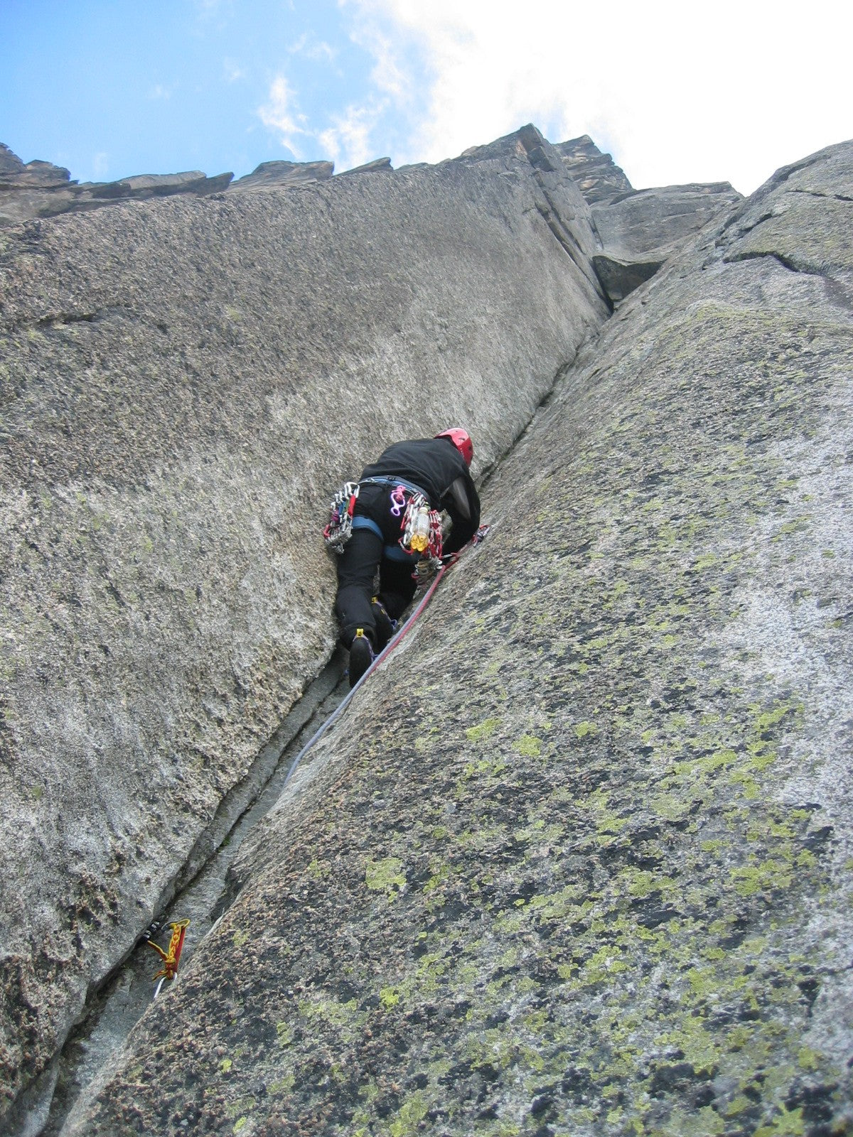 Rock climber ascending a granite crack during an active outdoor session