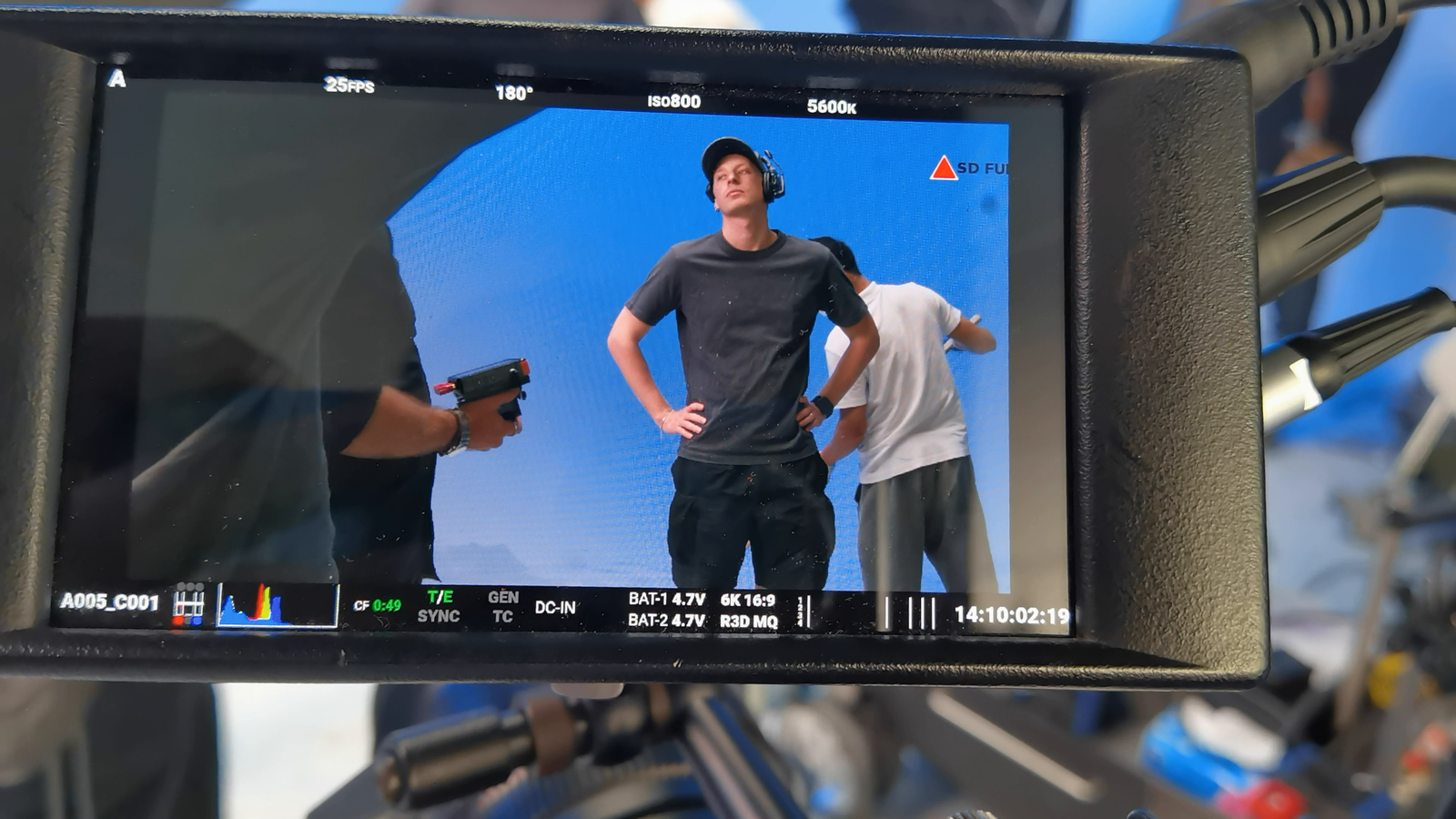 Production monitor framing talent on the blue studio set during a live capture setup