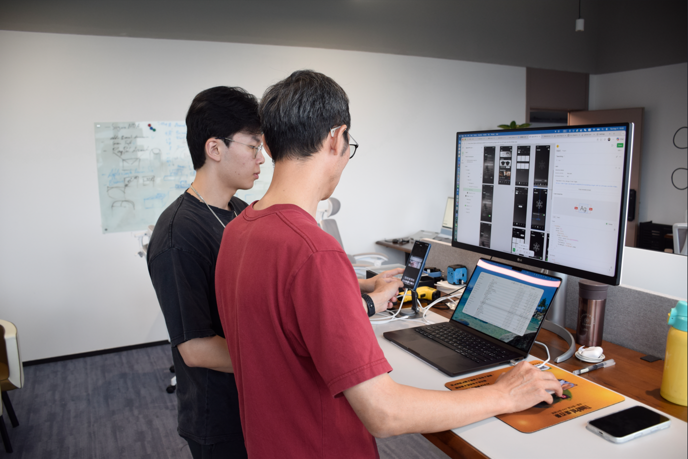 Two 8ight team members testing the mobile app at an engineering workstation