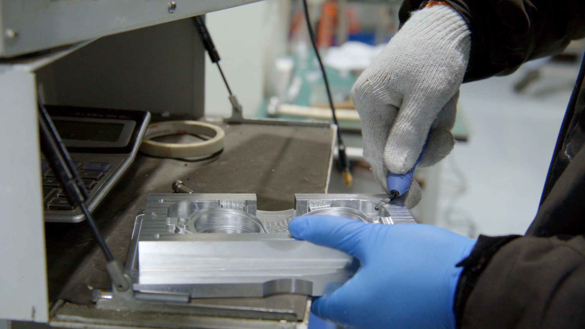 Technician inspecting machined tooling during camera-glasses development