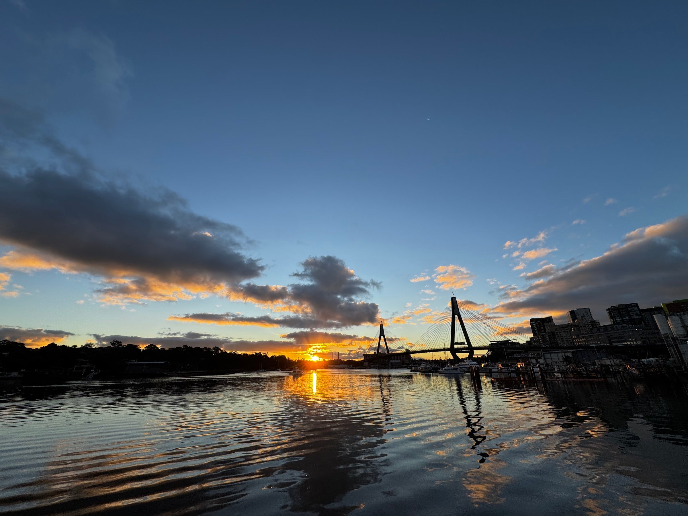 Calm waterfront and bridge at sunset