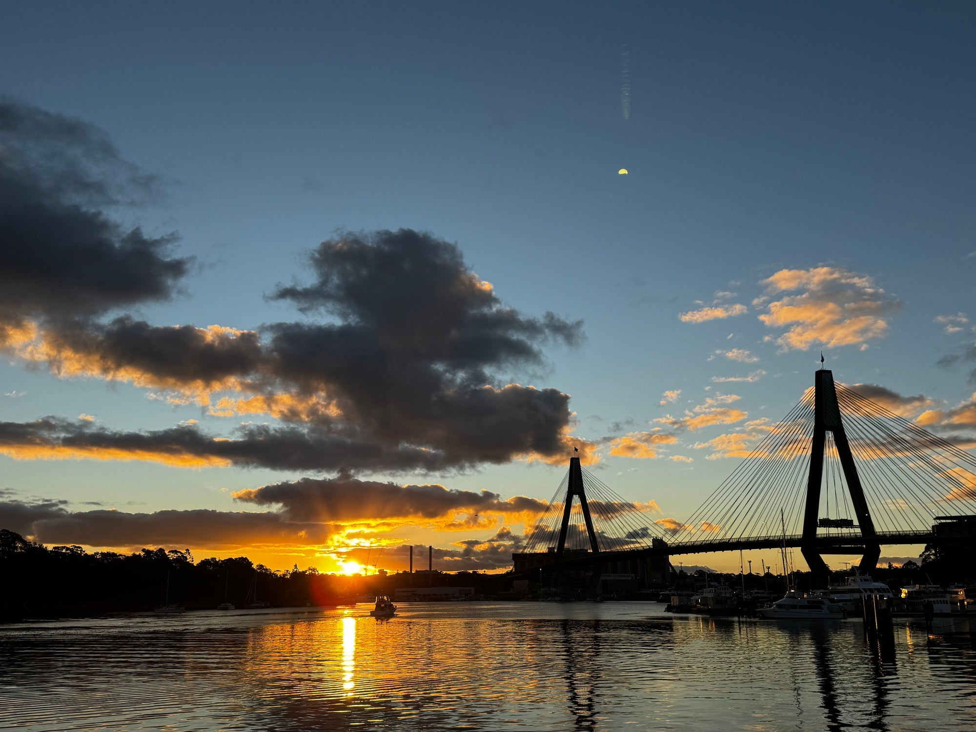 Warm sunset across a marina and bridge during an everyday waterfront moment
