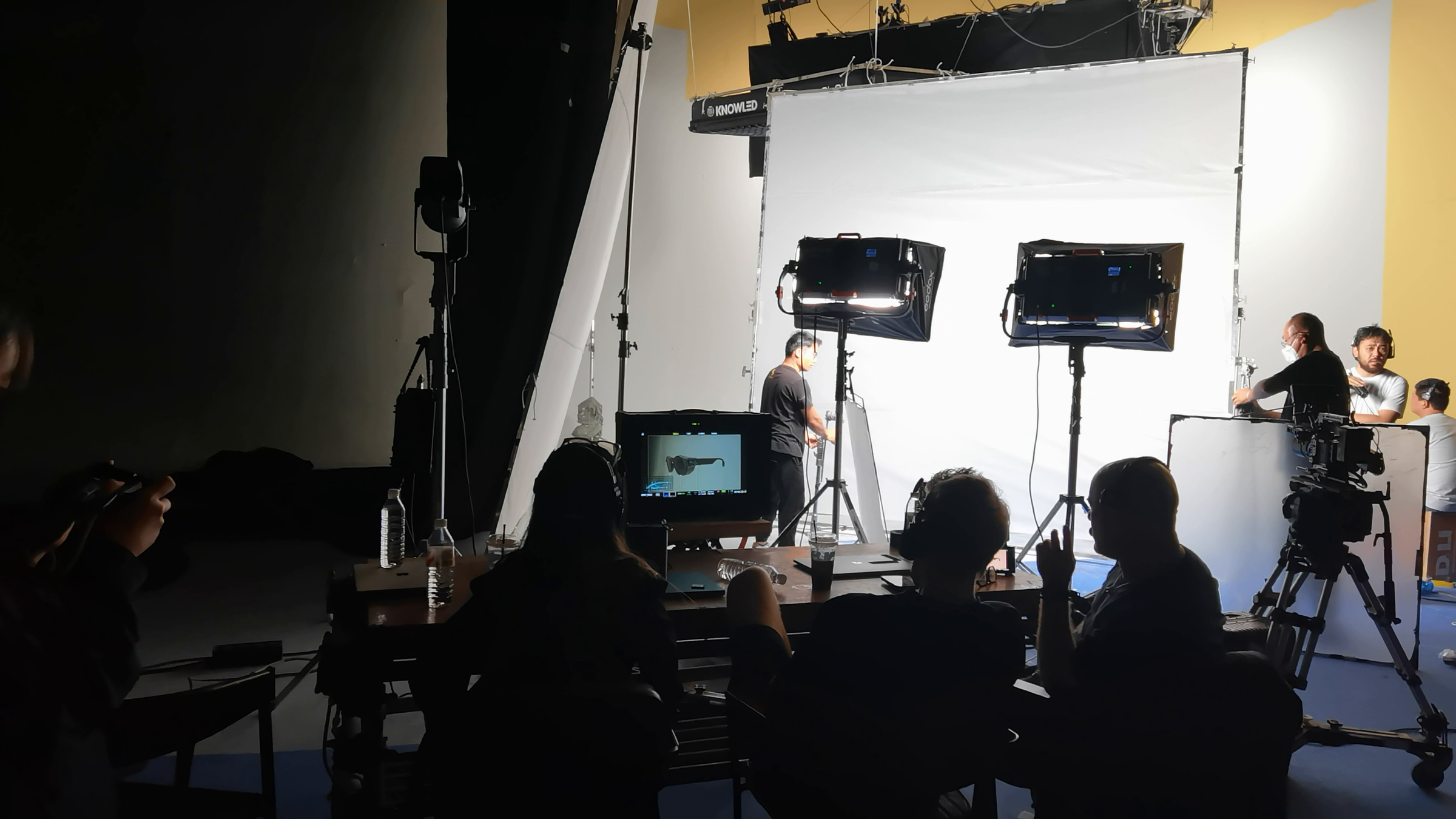Wide view of the 8ight production team working across a white cyclorama set